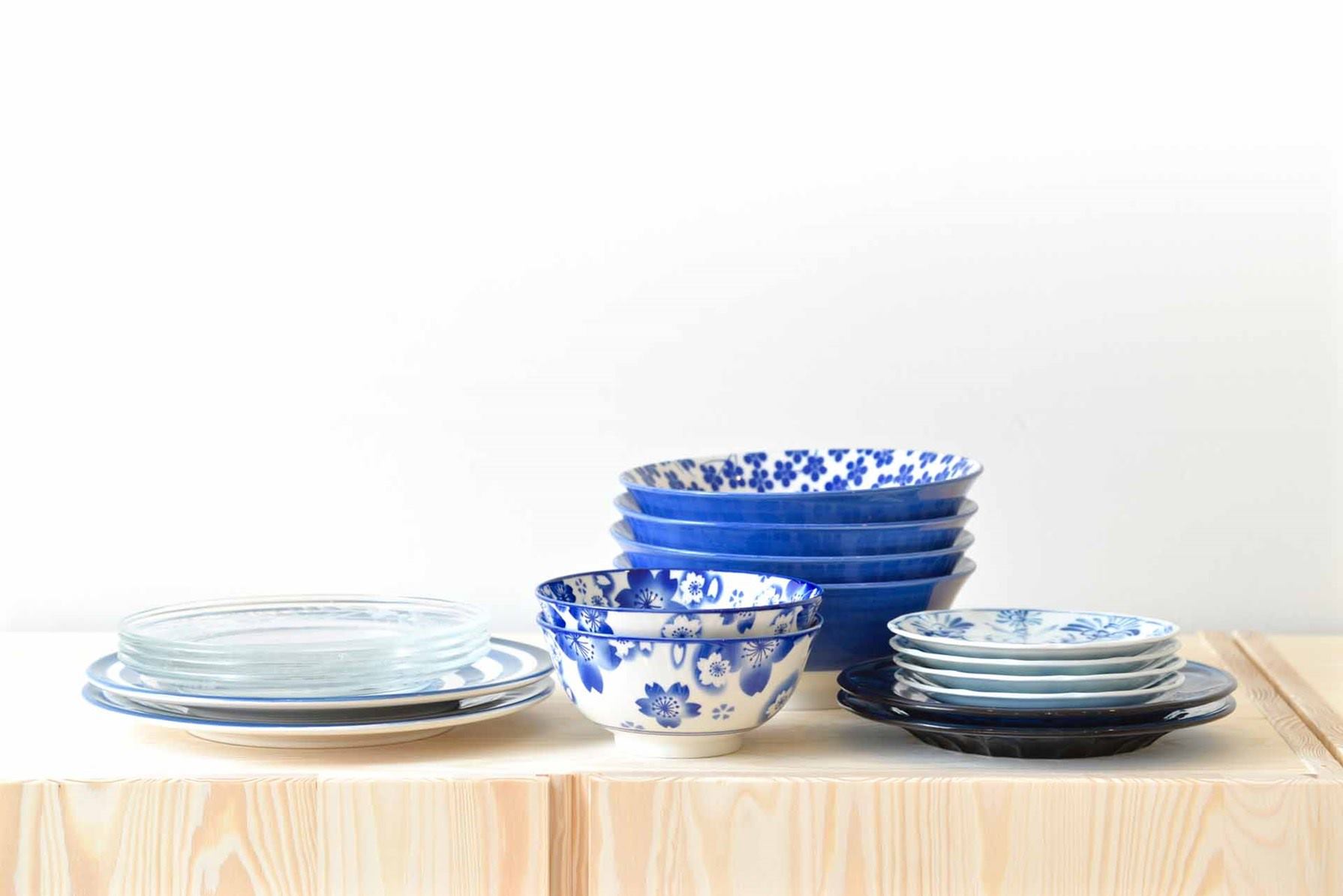 Platos y tazas de cerámica color azul con detalles blancos. Están sobre una mesa